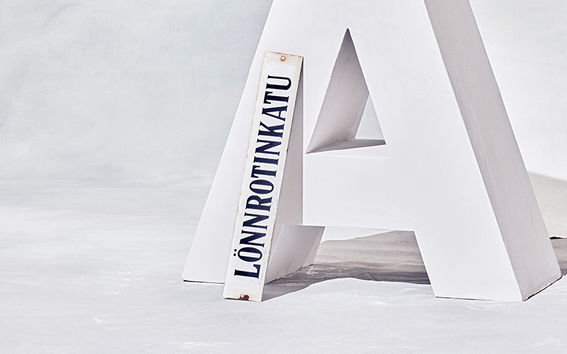 Kuvassa Lönnrotinkadun kyltti nojaa Aalto-logoon.