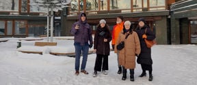 Researchers in front of Dipoli in a snowy landscape in Otaniemi 