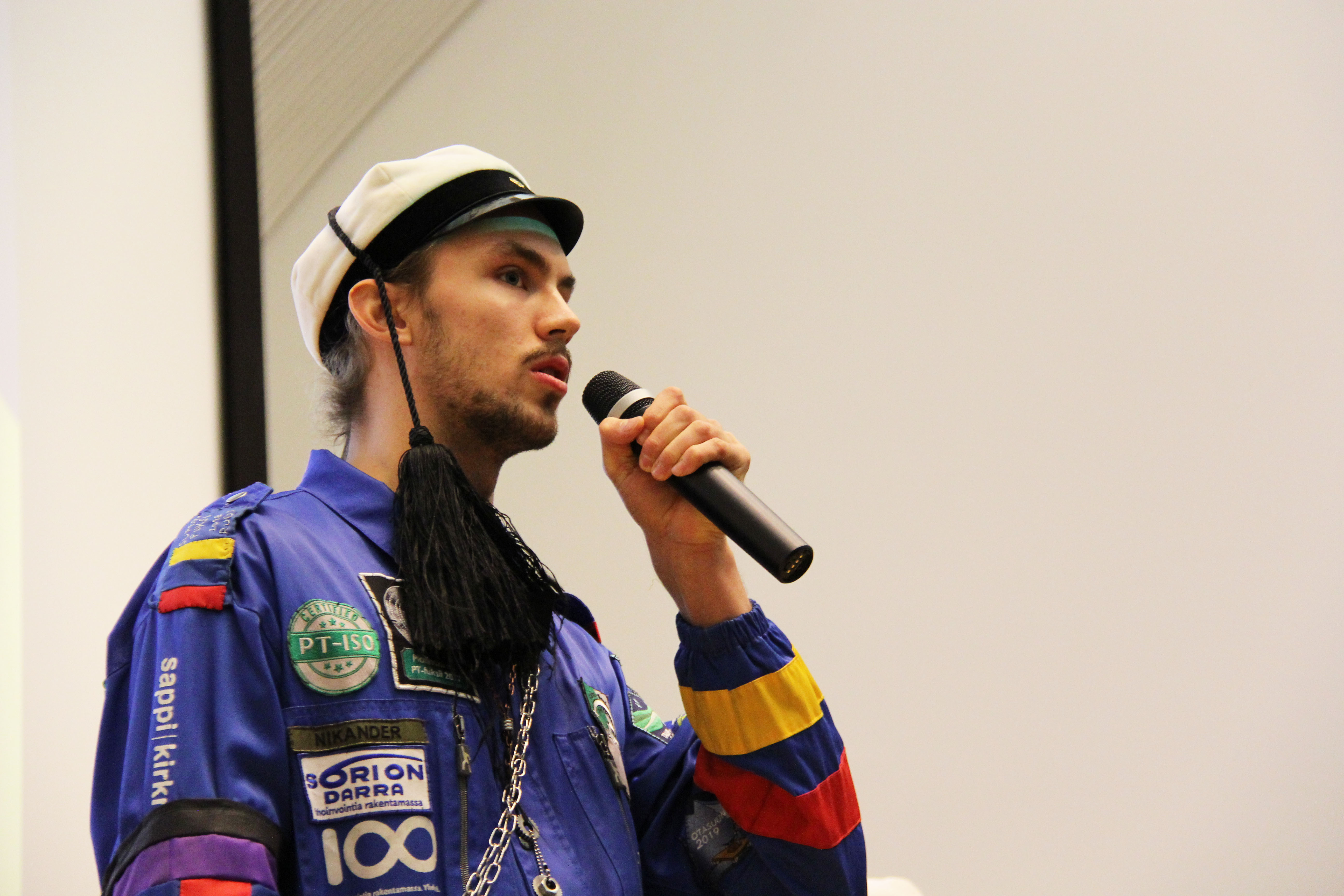 An image of Rudolf speaking into a microphone