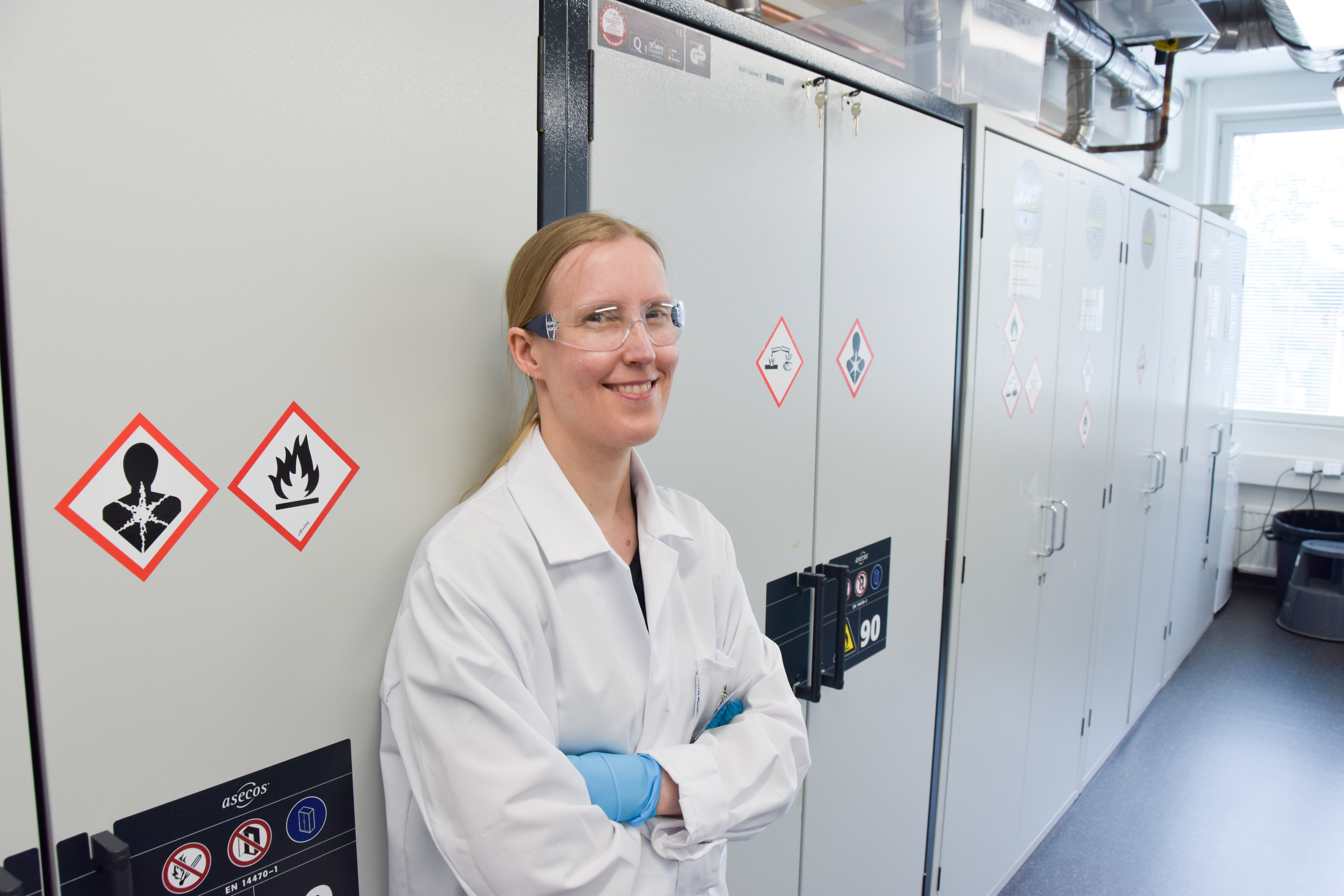 Taina in lab gear in the laboratoy smiling