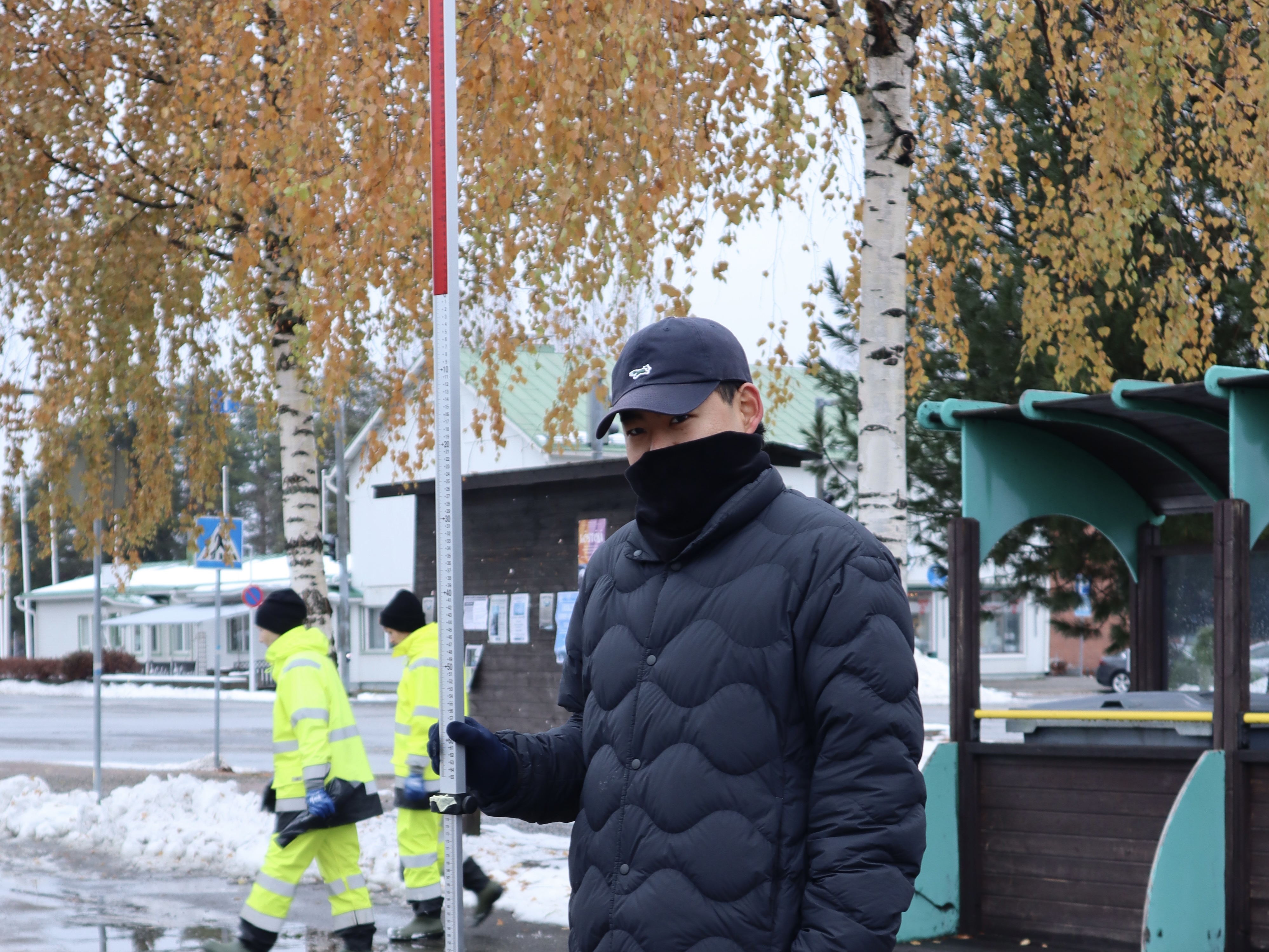 A Japanese member is standing with long ruler