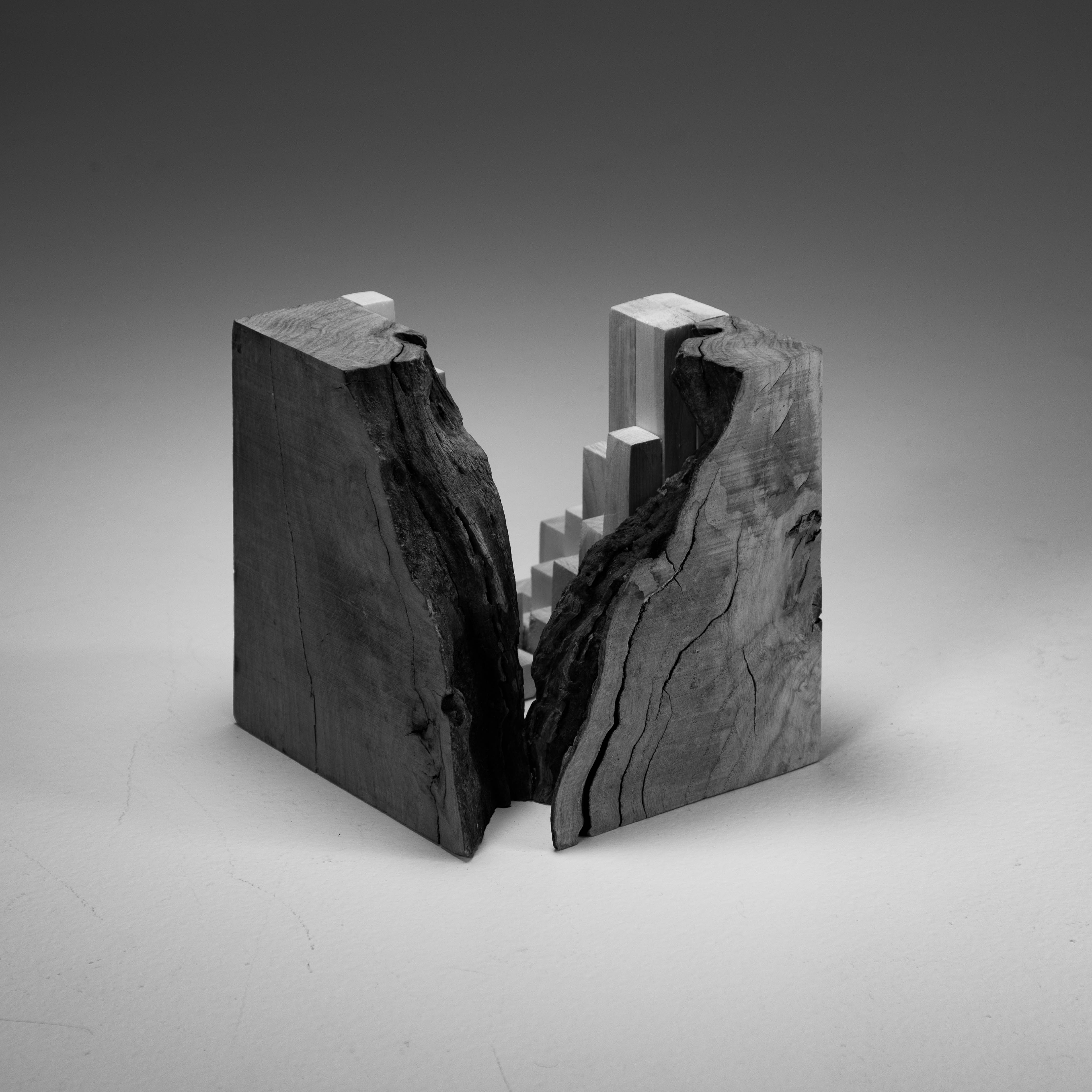 wood cube one half of which is rough edge wood, the other is more abstract consisting of square wood sections