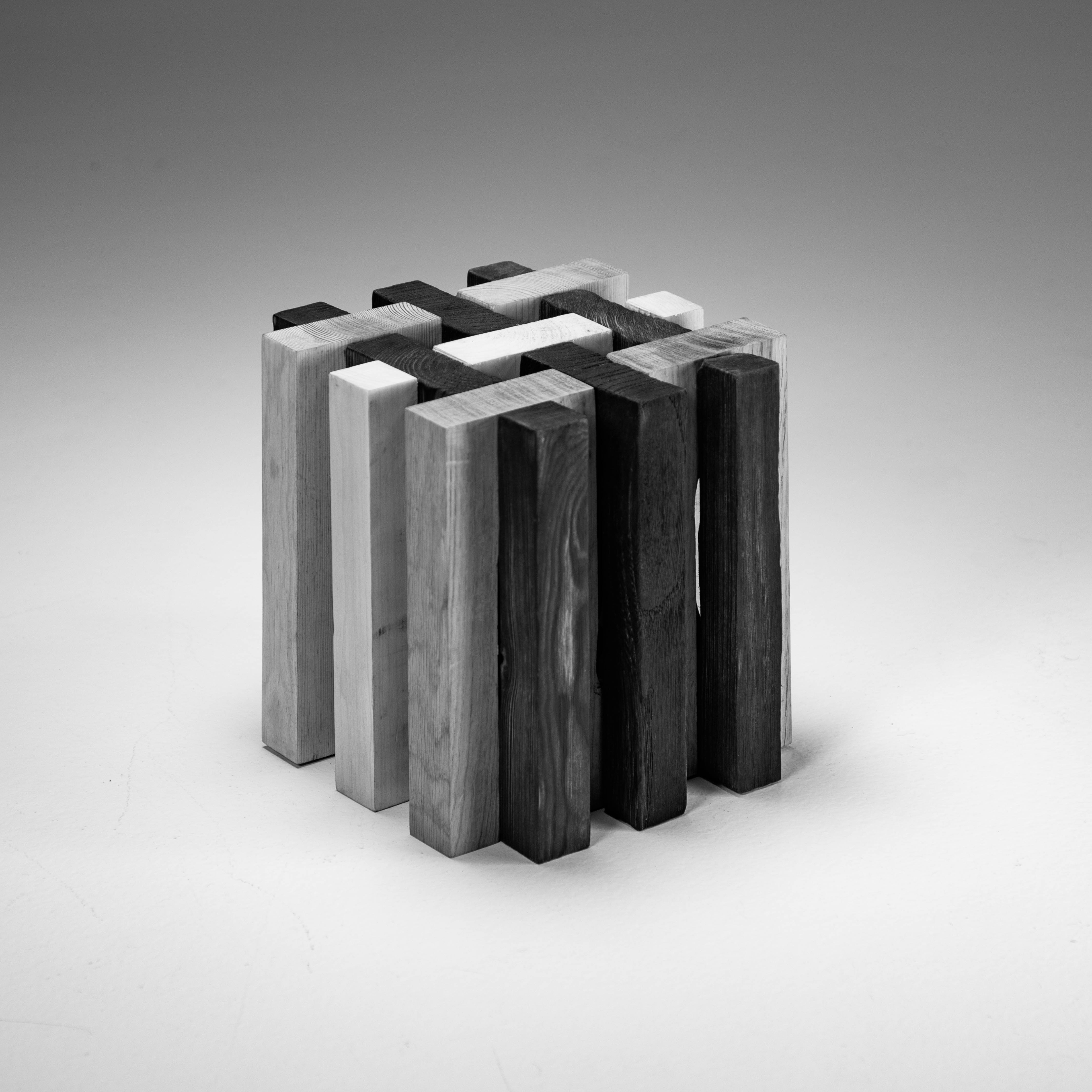 cube consisting of interlocking layers, of three different species; half of which have been charred.