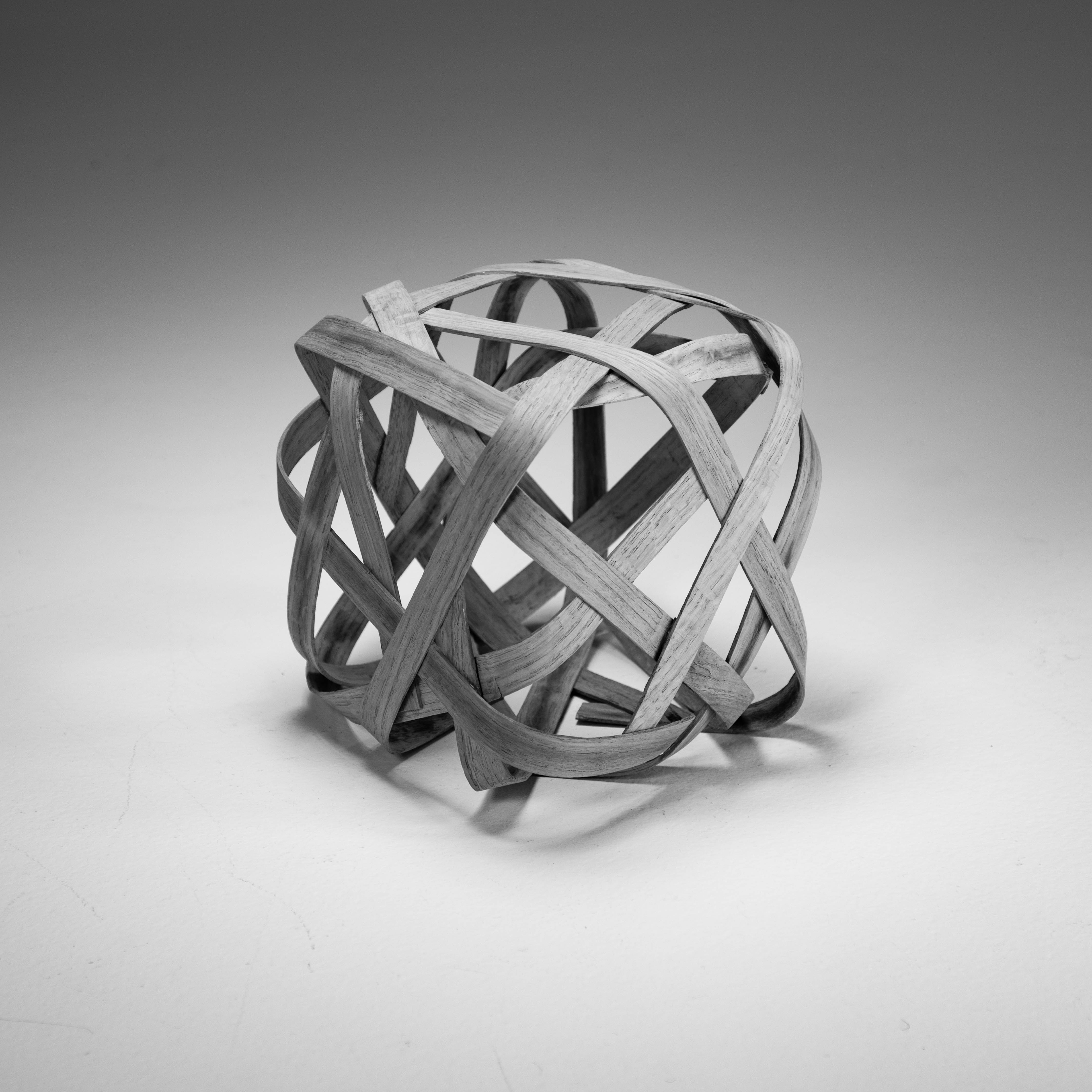 wood cube made by bending strips and gluing in square shape