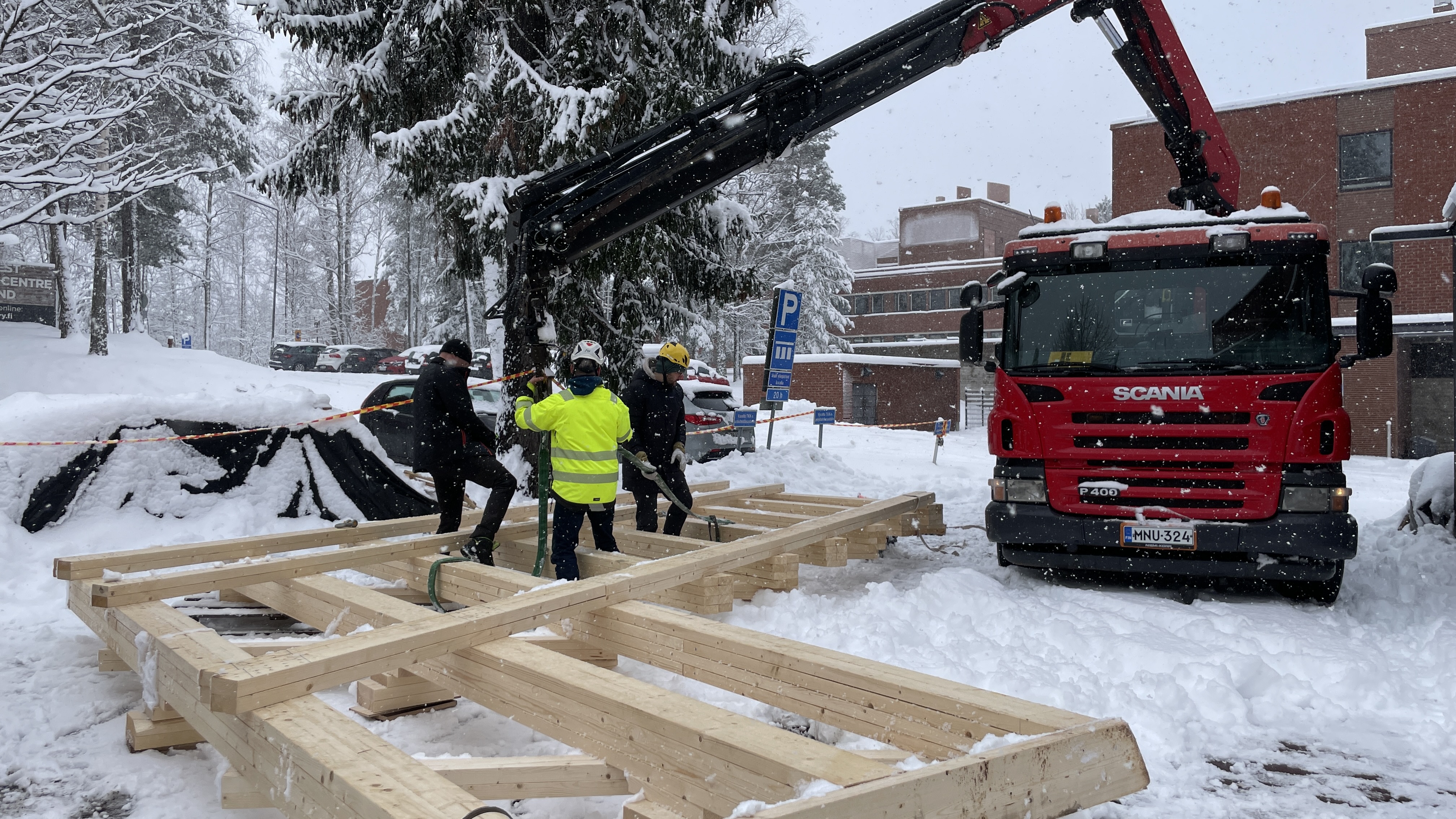 Truss being attached to the crane by students and crane driver