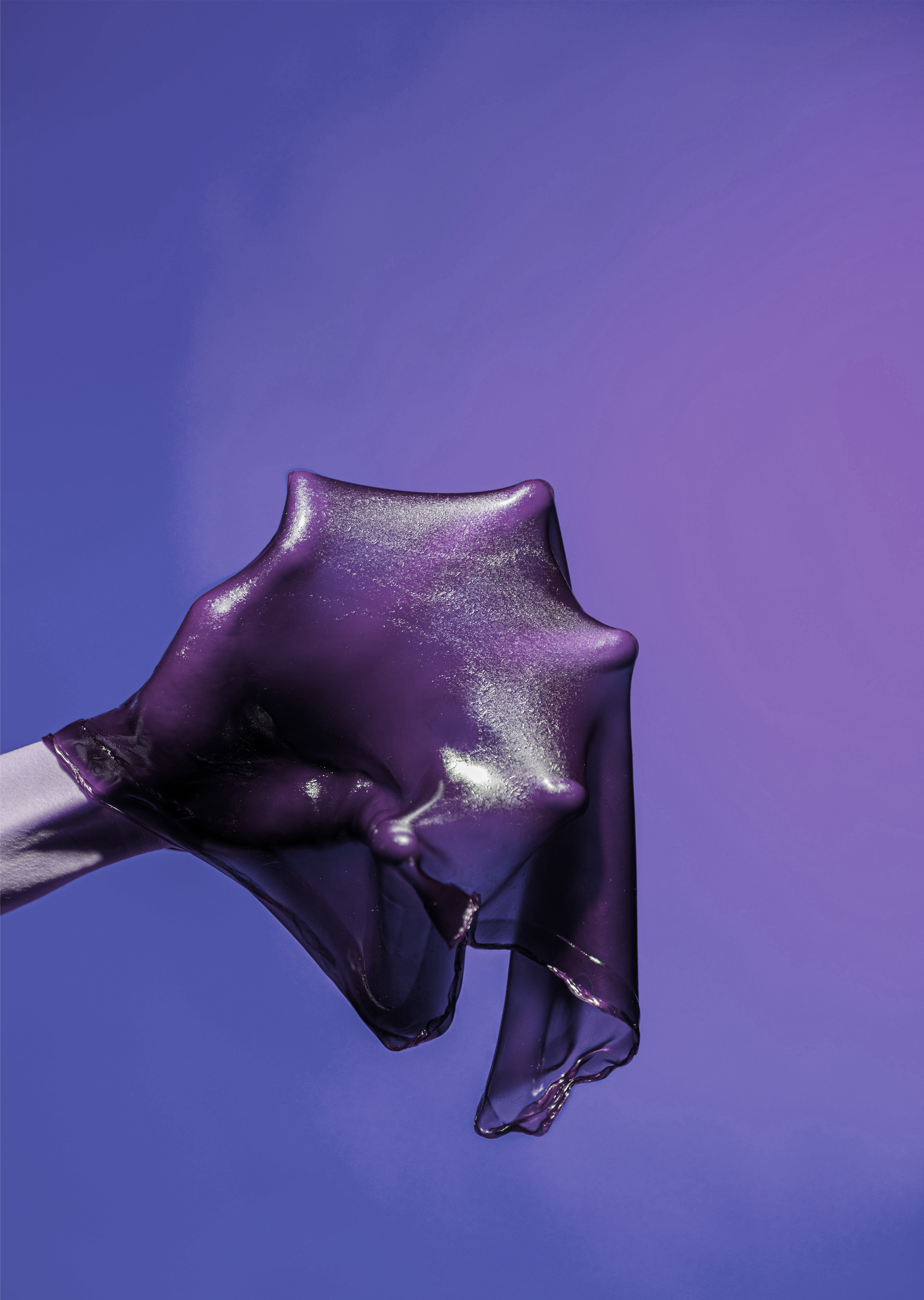 Violetinsävyinen kuva, jossa käsi pitelee venyvää materiaalia