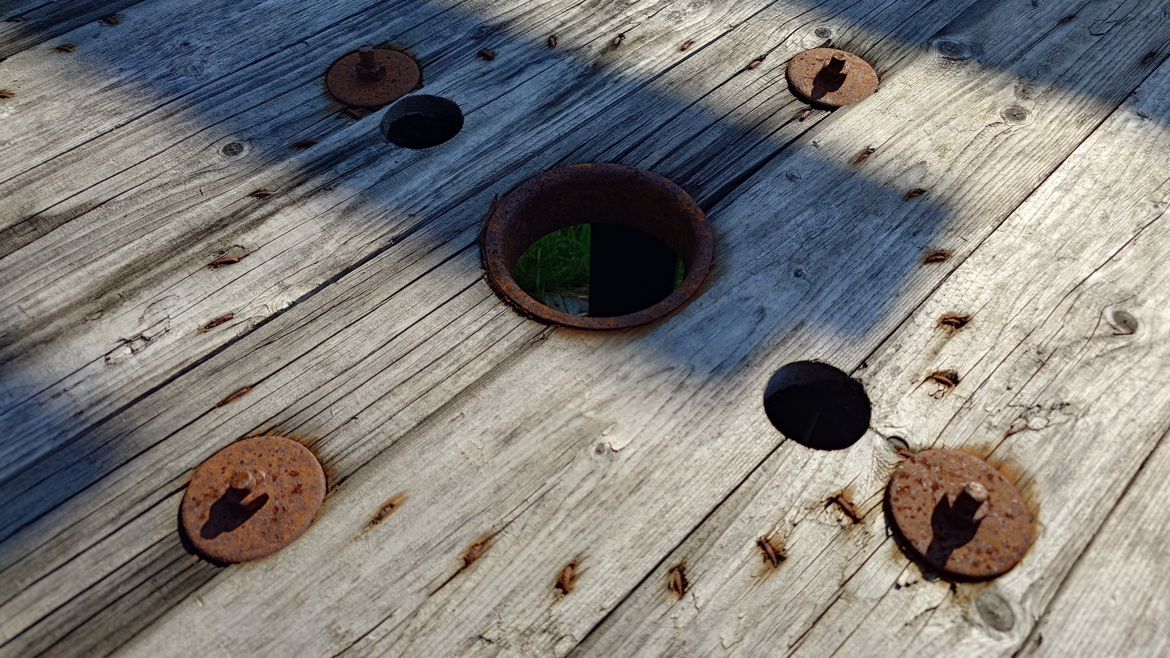 Rusty metal on grey wood