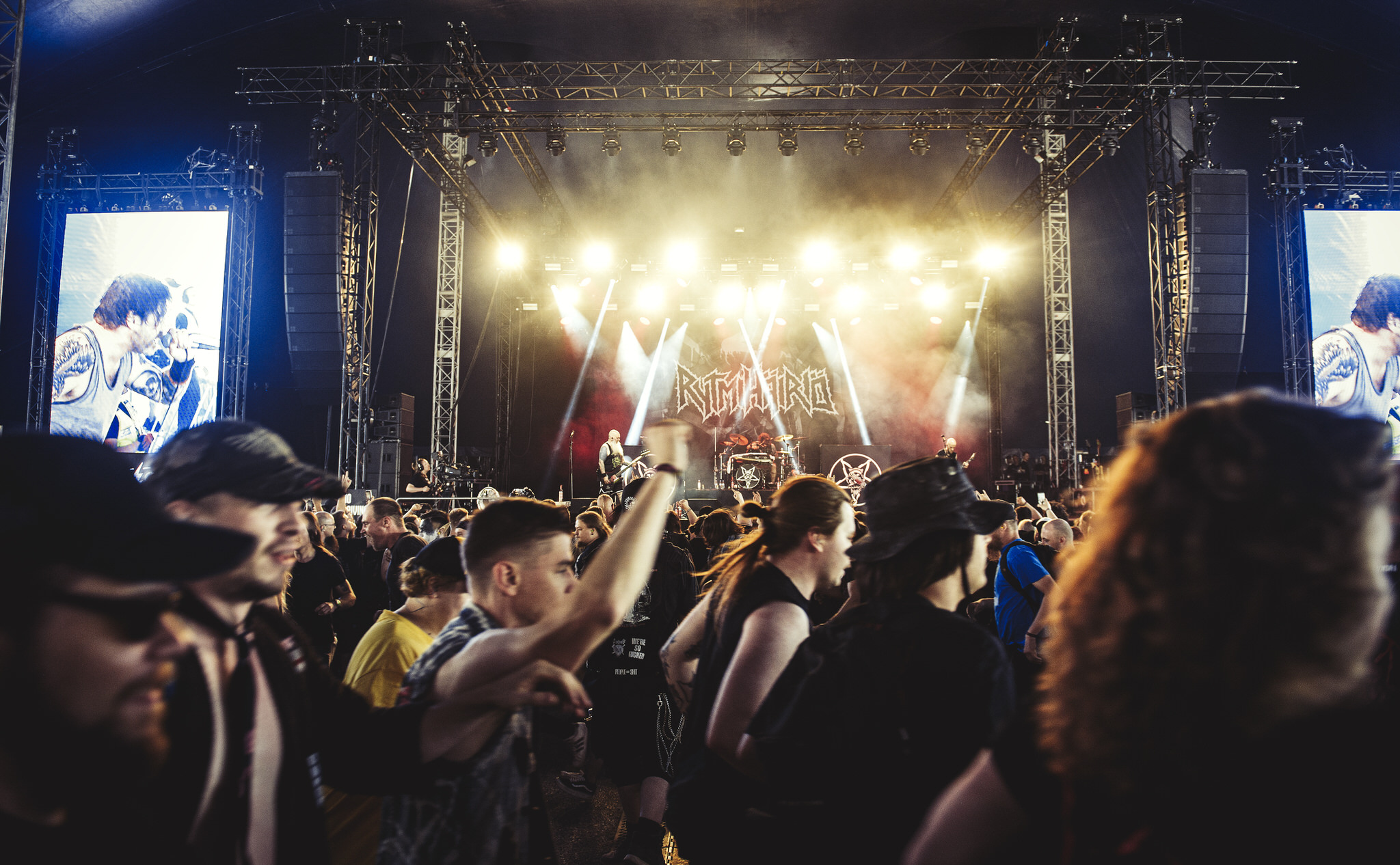 A lively heavy metal concert scene with a band performing under bright lights and a crowd enjoying the music.