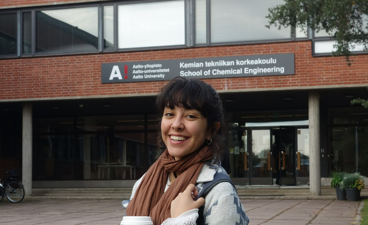 Individual holding a cup stands in front of Aalto University School of Chemical Engineering building.