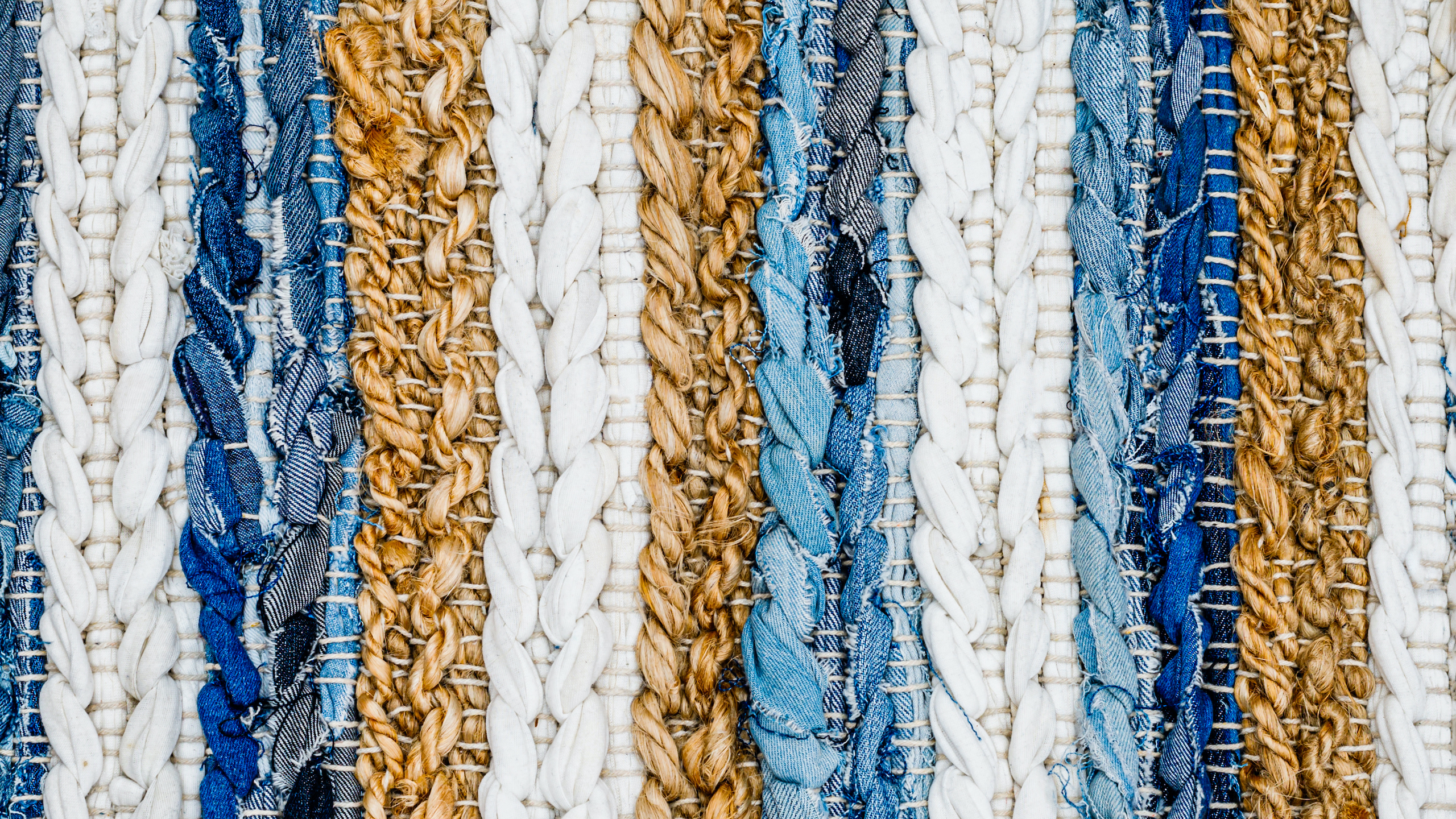 Close-up of a woven textile with vertical stripes in blue, white, and brown tones.