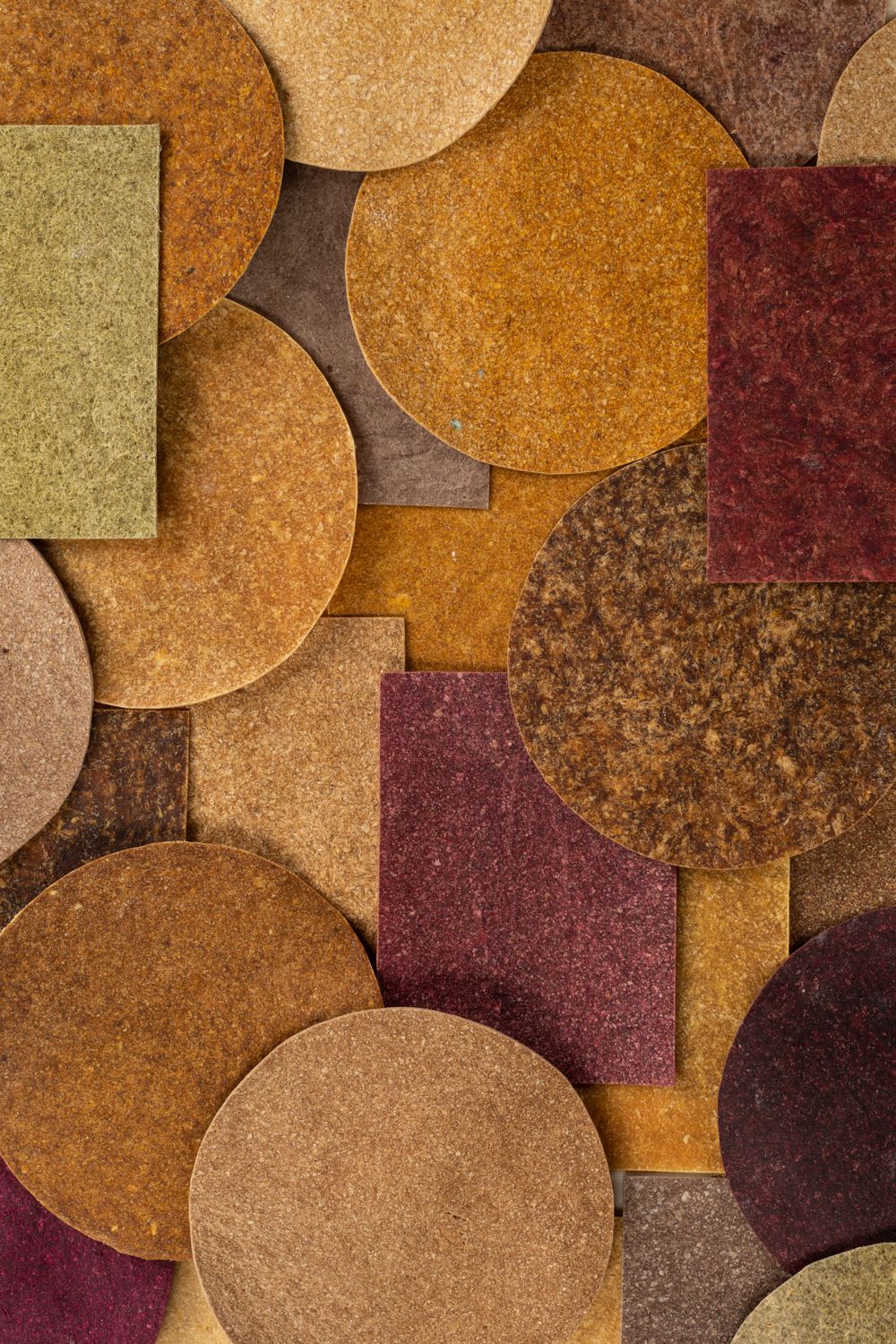 Ylimenevä tekstuurinen kollaasin pyöreistä ja suorakulmaisista muodoista maanläheisissä sävyissä, kuten ruskea ja beige.