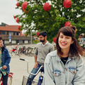 Three students with bicycles in front of Väre building, Aalto University