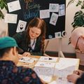 IDBM students gathered around a table and drawing