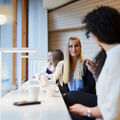 People drinking coffee in front of a desk