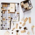 Board game featuring wooden blocks representing furniture and rooms. The picture is from a diploma work by Nhung Pham.