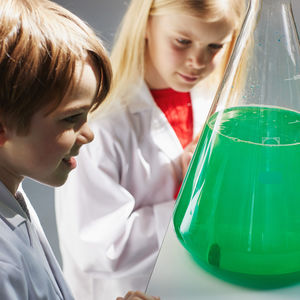 Kaksi lasta tutkii vihreää liuosta.