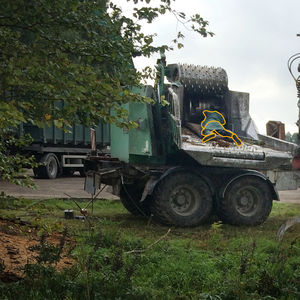 Photo of a leaf shredder with a man drawn over the photo as being crushed by the machine