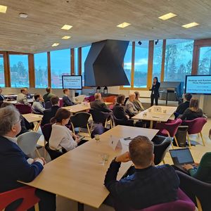 Audience in smaller tables listening to senior university lecturer Leena Lankoski