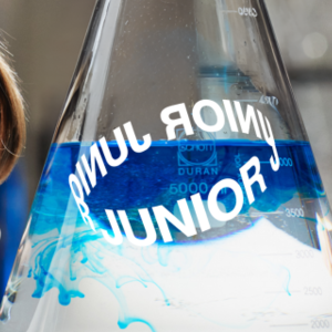 Lapsi ihailee suuressa dekantterissa liikkuvia värejä.