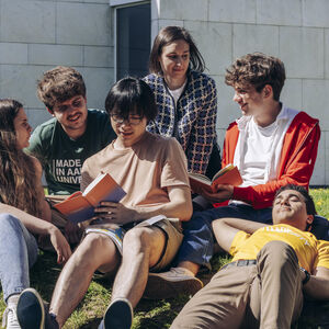Students hanging out outside on the lawn at university campus