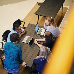 Four Aalto University students working at a table / photo by Unto Rautio