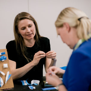 Kaksi naista tekemässä kankaisia rintamerkkejä. Kuva: Marko Oikarinen / Aalto-yliopisto