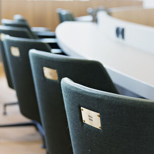 Tuoleja, joissa on lahjoittajan nimilaatta. 