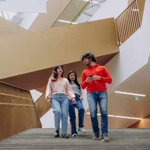 Aalto students walking down the stairs of Aalto University School of Business.
