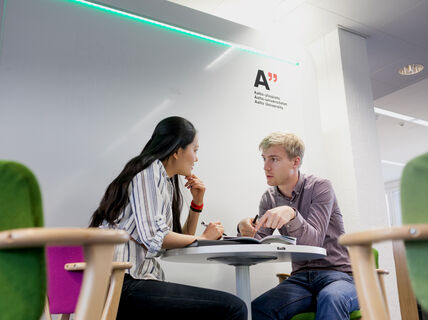 Counselling discussion where two persons discus sitting at a table.