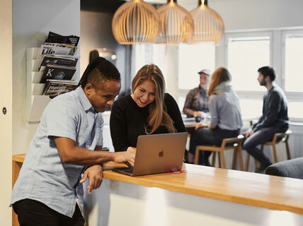 Kuvassa kaksi opiskelijaa tutkii tietokoneen ruutua pöydän molemmin puolin. Photo: Unto Rautio