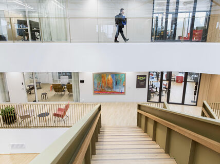 Alaspäin vievät portaat, projektitiloja lasiseinien takana