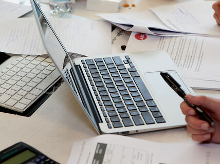 A laptop and papers on a table.