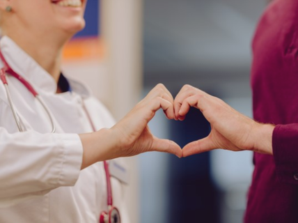 Doctor patient encounter with hands forming a heart
