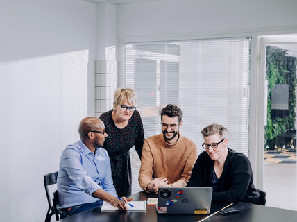Four people looking at the laptop. Image: Aalto University / Aleksi Poutanen