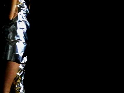 a person dressed in tin foil with black background