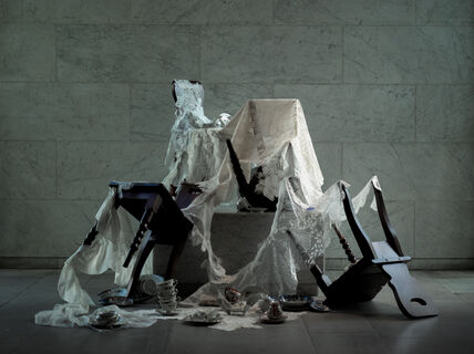 an installation with chairs and tableware