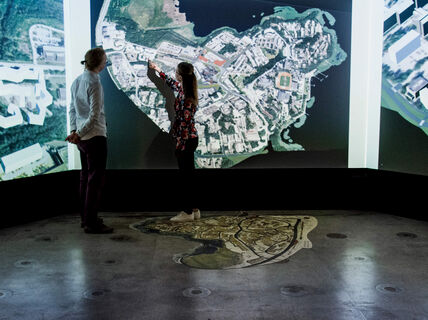 Kaksi henkilöä kuvan äärellä