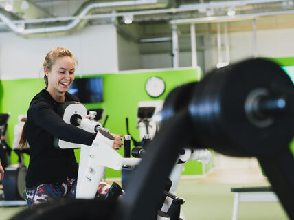 Nainen treenaamassa kuntosalilla