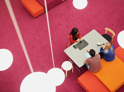 People are discussing around a table in the Learning Center. 