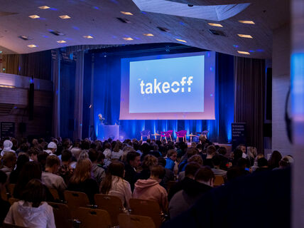 Nuoria kuuntelemassa tapahtuman ohjelmaa.