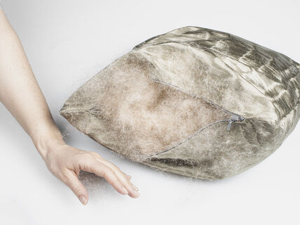 Höytyvällä täytetty tyyny ja naisen käsi sen vieressä.