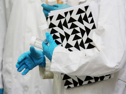 Lab coat, folder and lab gloves. Photo by Aalto University, Kitty Norros