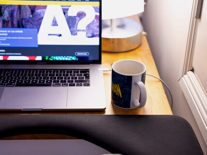 PC on a desk with coffee mug next to it