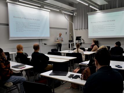 Henkilö luennoi luokan edessä henkilöstön jäsenille 