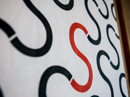 Photo of a part of a painting with letters S painted on white background