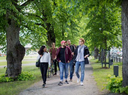 Teachers and students walking outdoors. They're discussion the Sustainability in Teaching course.