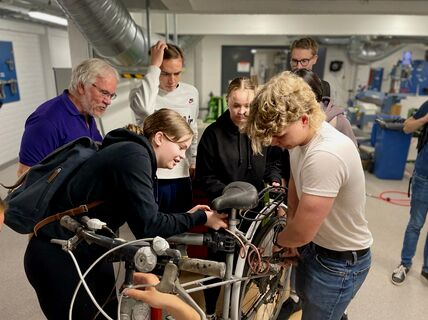 Students pull a bicycle apart