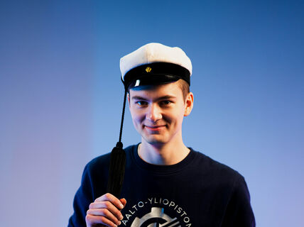 Leevi Oikarinen teekkarilakki päässä studiossa.