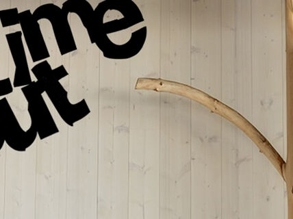 kuva pikku finlandian puupilarista ja teksti time out