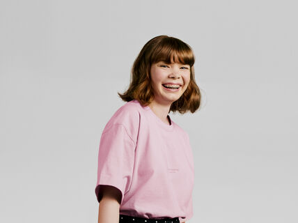 Nuori nauraa ja katsoo kameraan